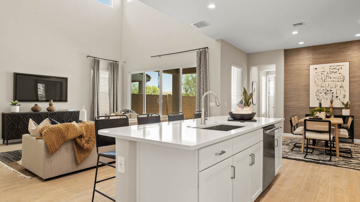 Bright and spacious kitchen with quartz countertops, stainless steel appliances, and an island with bar seating.