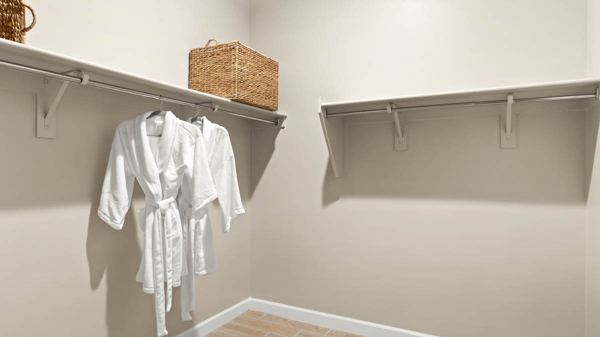 Modern primary bathroom with double vanities, quartz countertops with a walk-in shower and a walk-in closet.