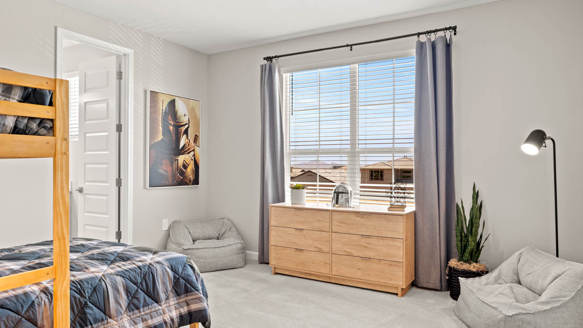 A vibrant kids' bedroom showcasing a neatly made bed, a stylish dresser, and a playful painting that adds charm.