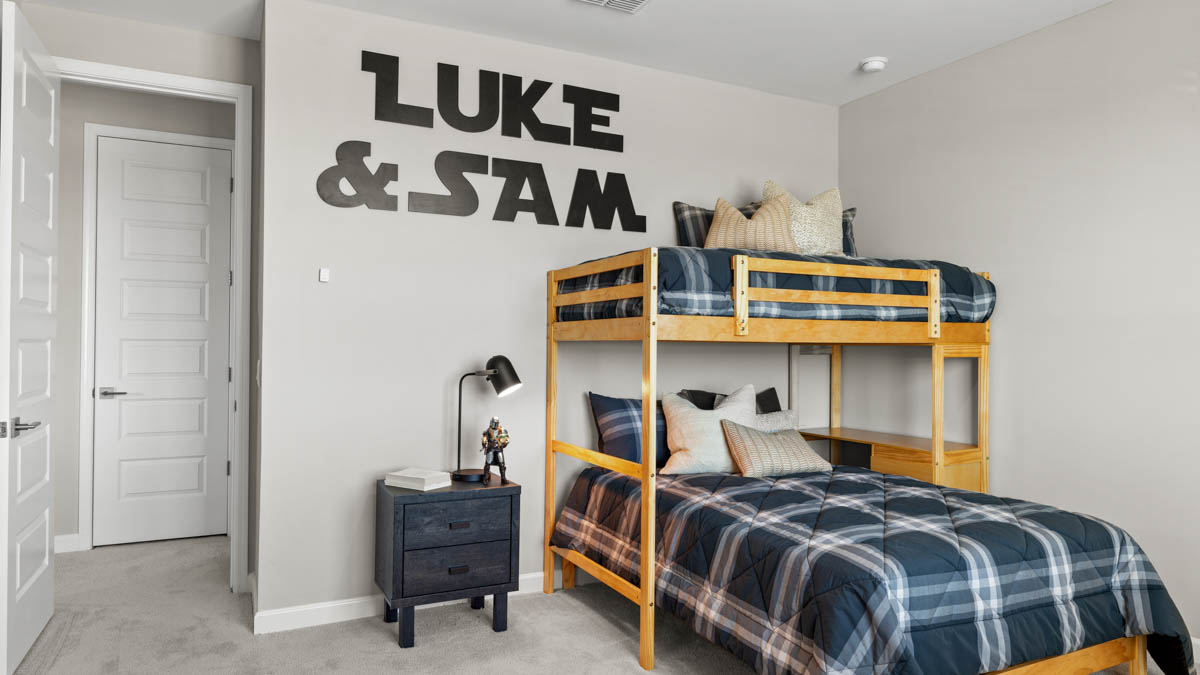A vibrant kids' bedroom showcasing a neatly made bed, a stylish dresser, and a playful painting that adds charm.