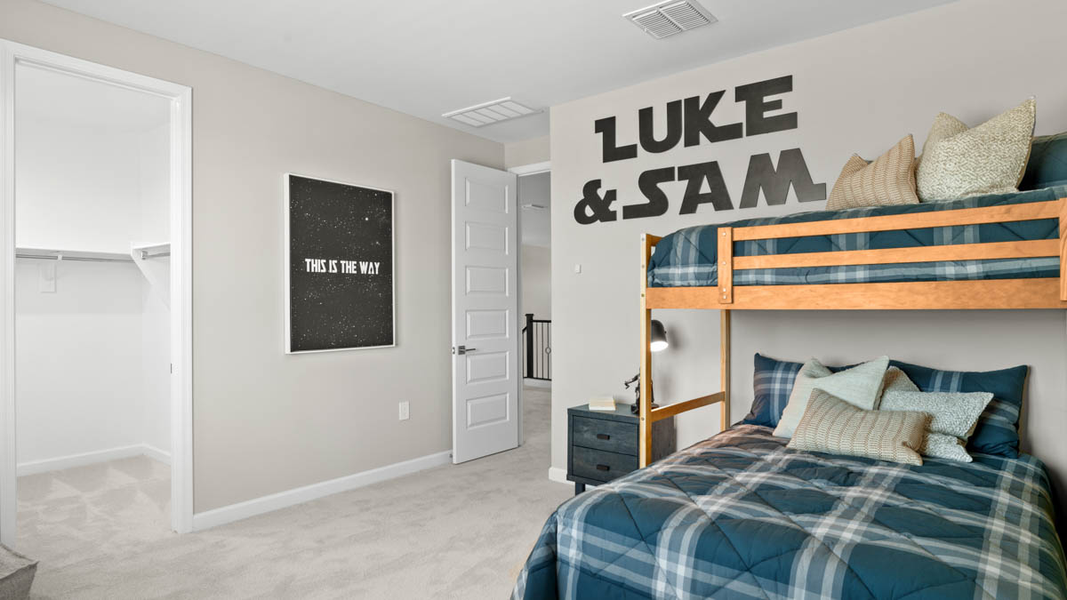 A vibrant kids' bedroom showcasing a neatly made bed, a stylish dresser, and a playful painting that adds charm.