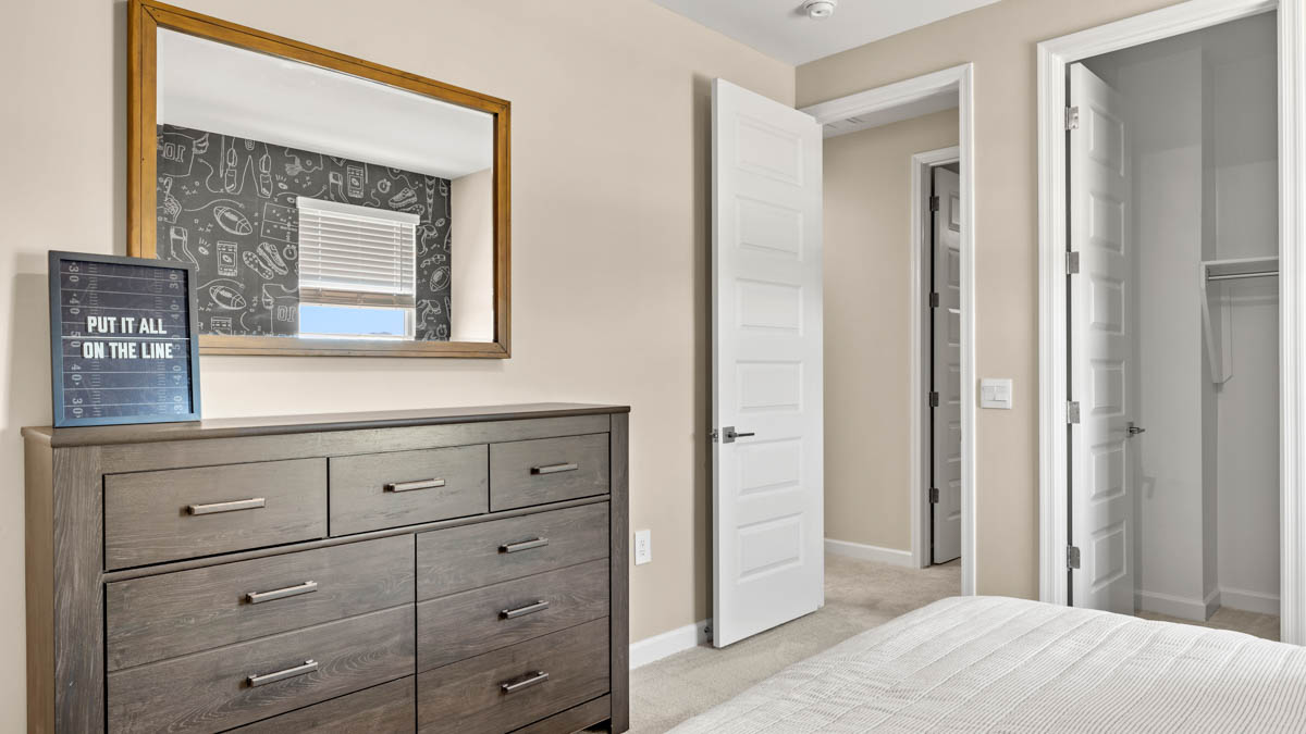 Comfortable guest bedroom featuring neutral-toned walls and a large closet.