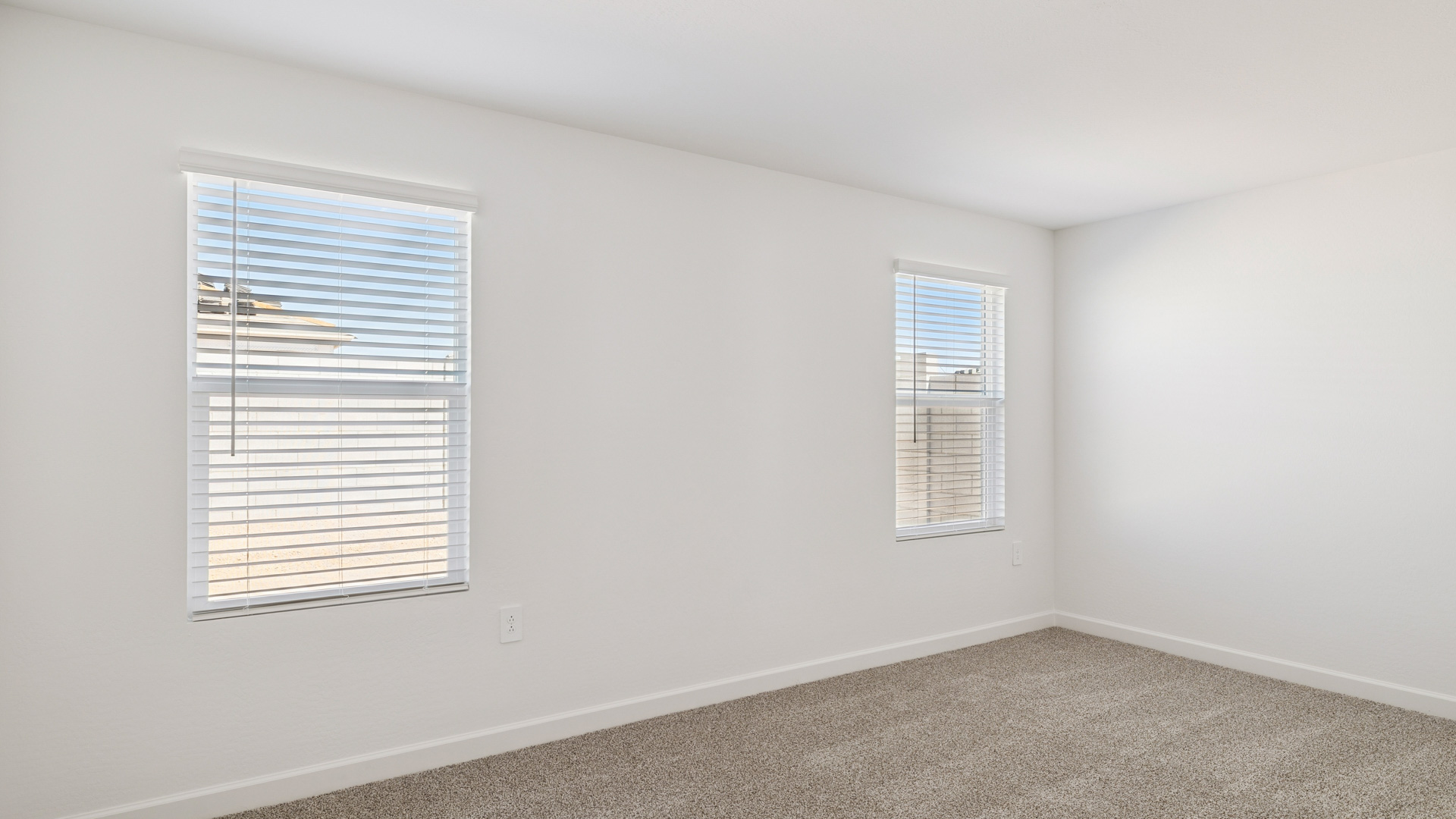 A spacious primary bedroom emphasizing open space and natural lighting.