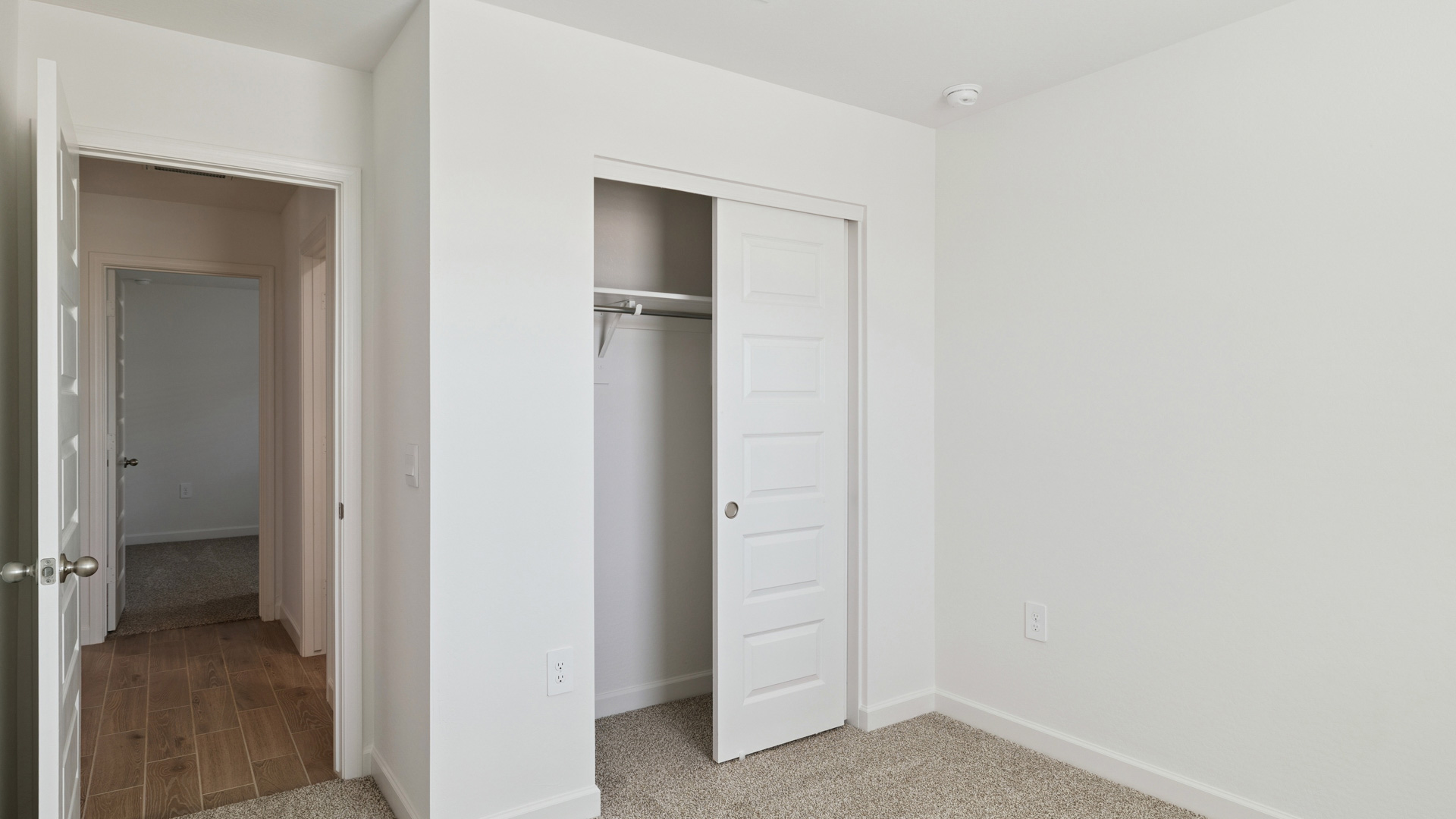 Comfortable guest bedroom featuring neutral-toned walls and a large closet.