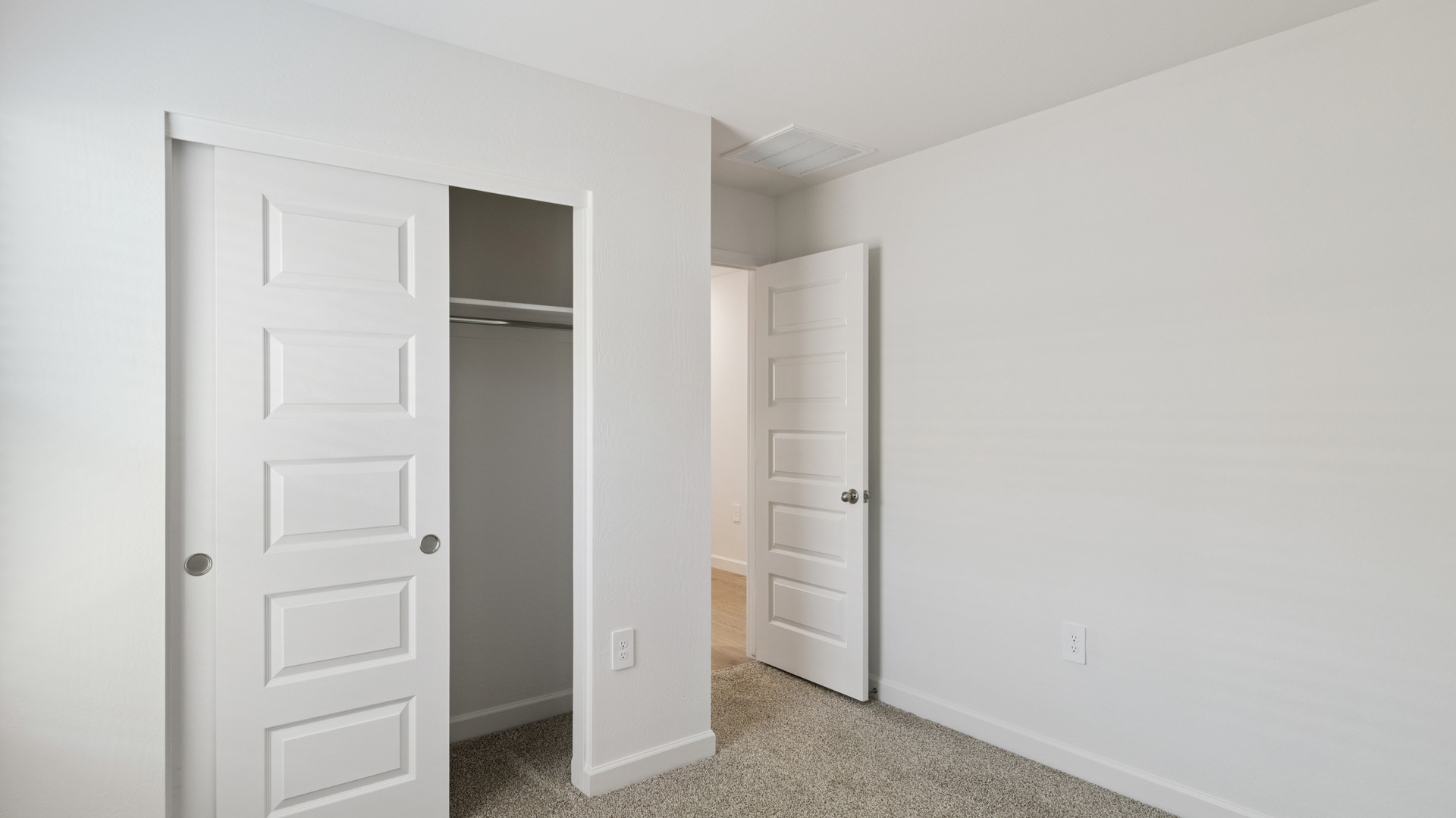 Comfortable guest bedroom featuring neutral-toned walls and a large closet.