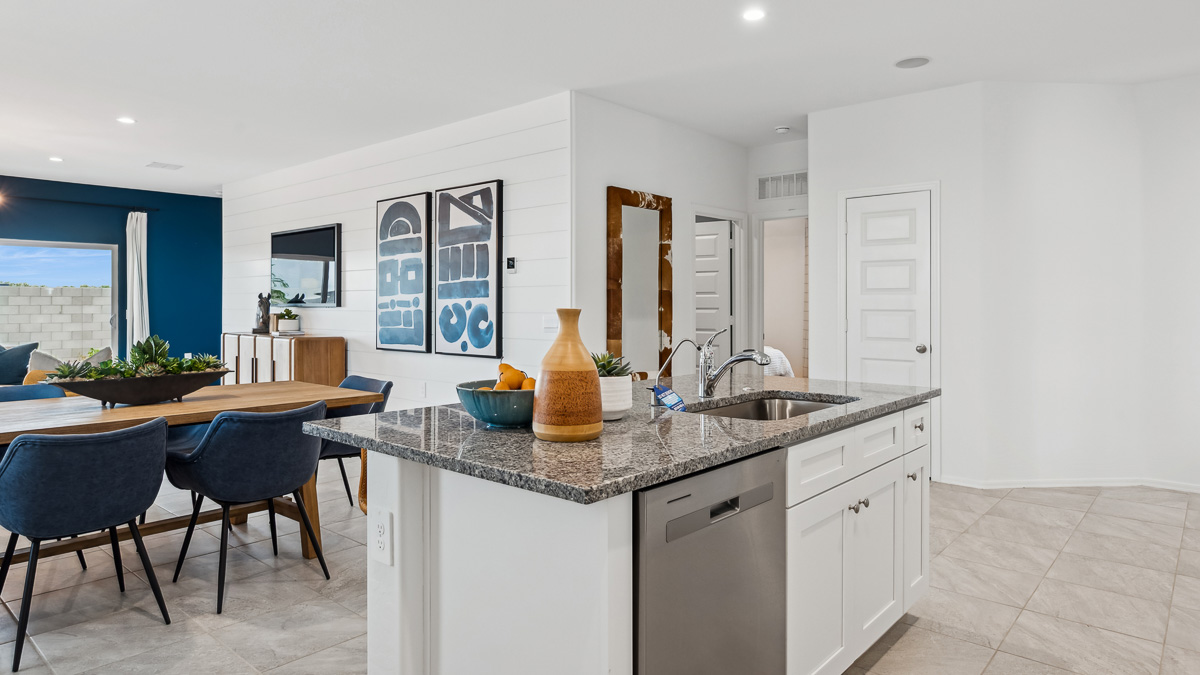 Bright and spacious kitchen with granite countertops, stainless steel appliances, and an island with bar seating.