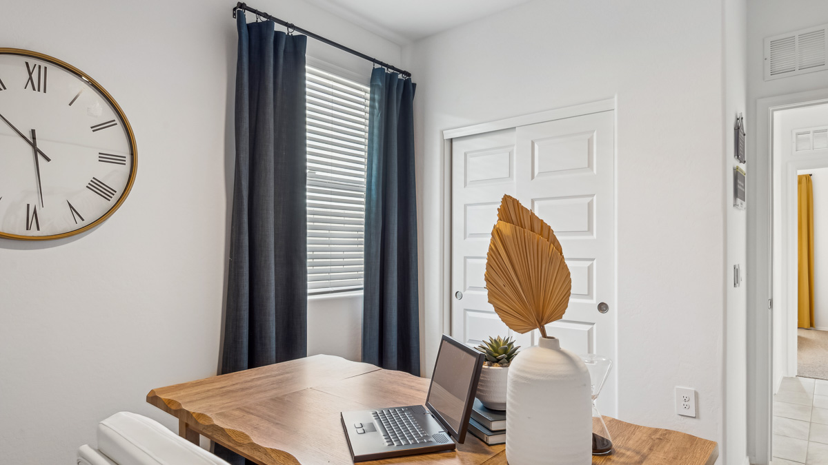 A tidy office featuring a desk, chair, and a window, creating a bright and organized workspace.
