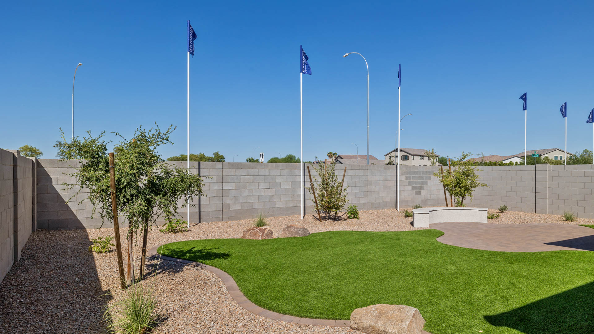 Outdoor covered patio with seating area overlooking a well-maintained lawn, perfect for relaxation.