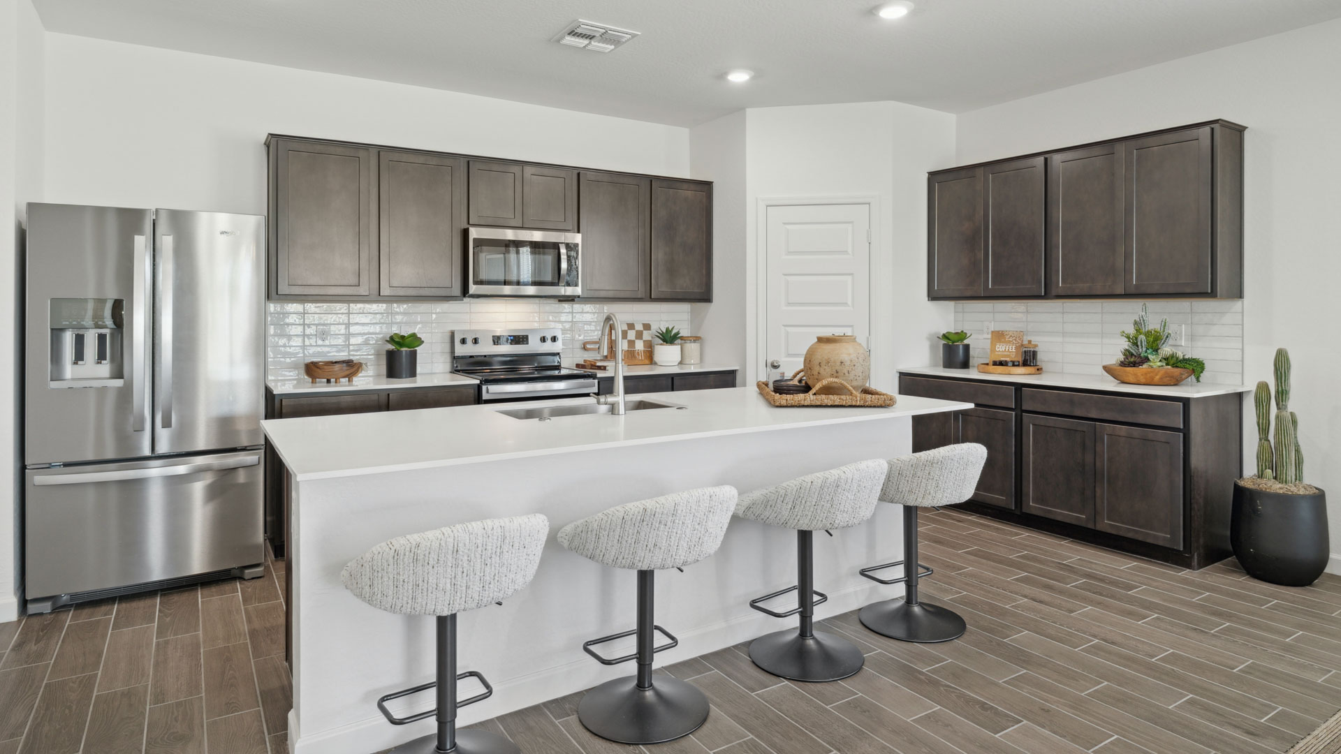 Spacious kitchen with island and stainless steel appliances.