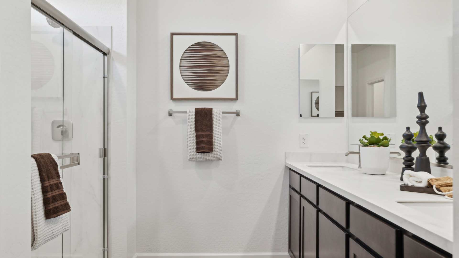 Primary bathroom with dual vanities and a walk-in shower.