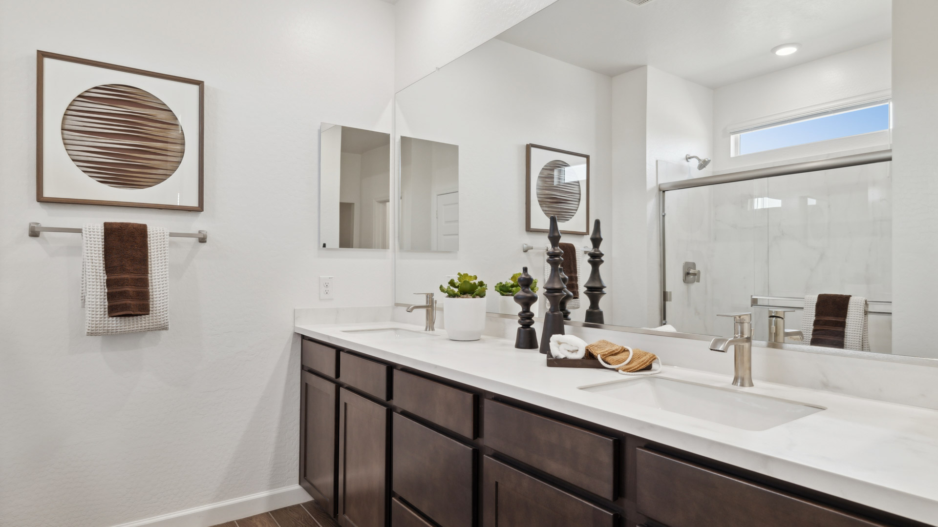 Primary bathroom with dual vanities and a walk-in shower.