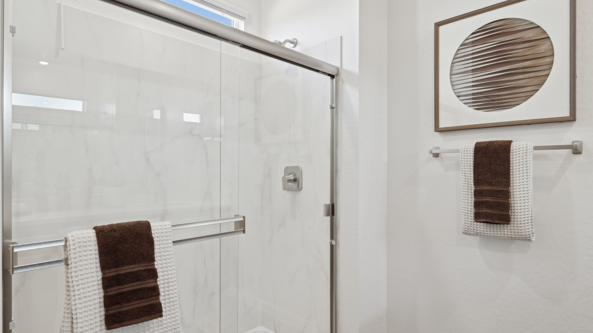 Primary bathroom with dual vanities and a walk-in shower.