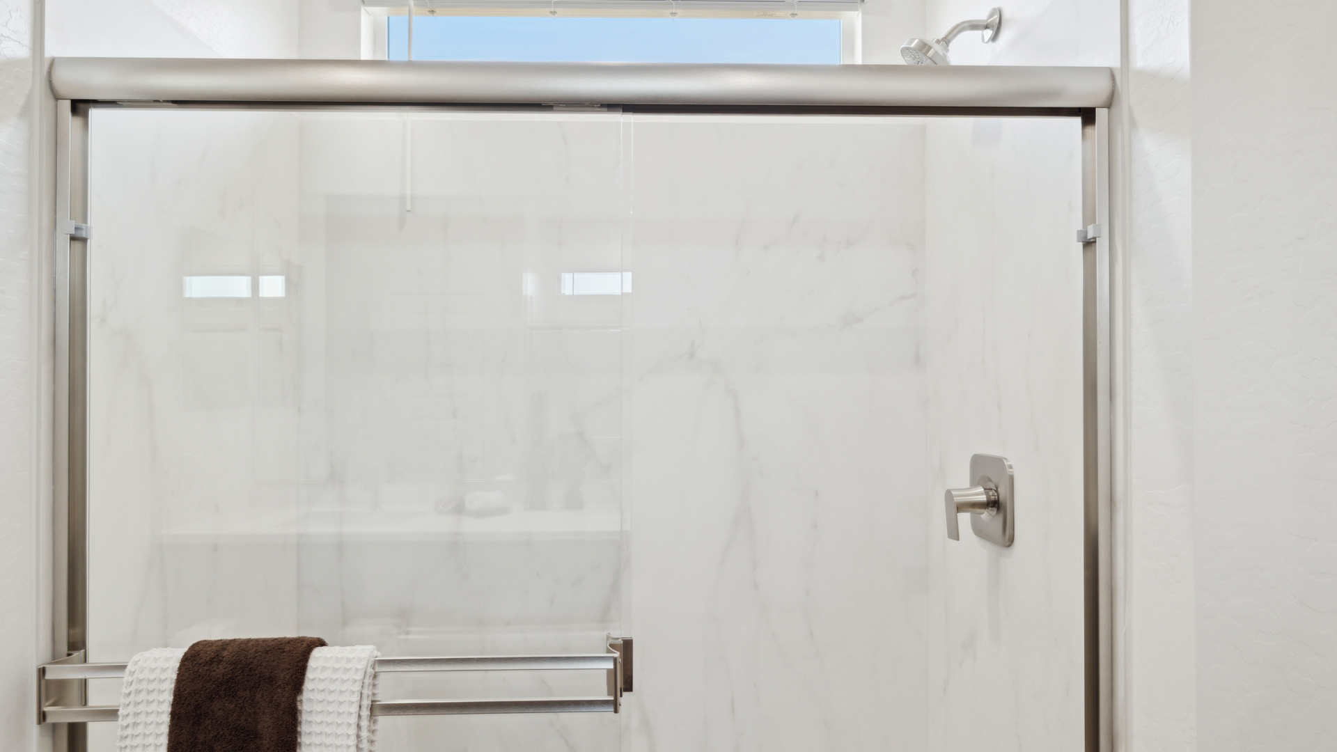 Primary bathroom with dual vanities and a walk-in shower.