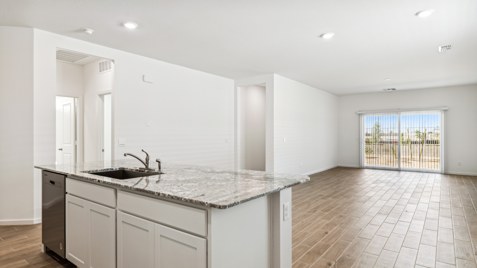 Bright and spacious kitchen with granite countertops, stainless steel appliances, and an island with bar seating.