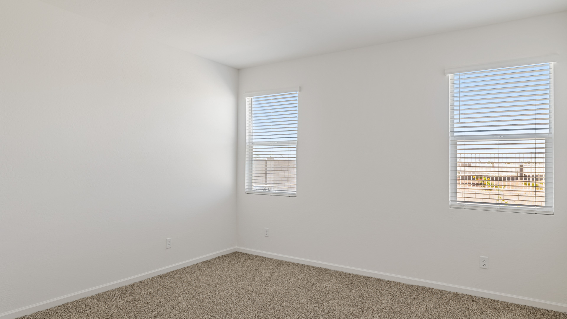 A spacious primary bedroom emphasizing open space and natural lighting.