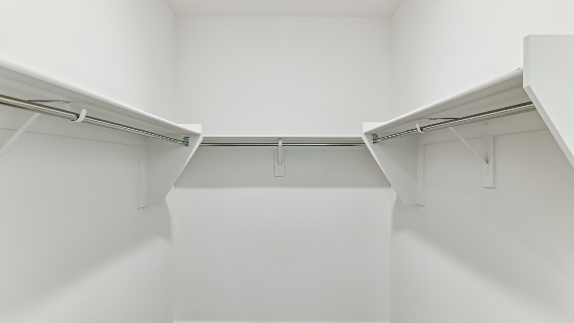 Modern primary bathroom with double vanity, granite countertops with a walk-in shower and a walk-in closet.