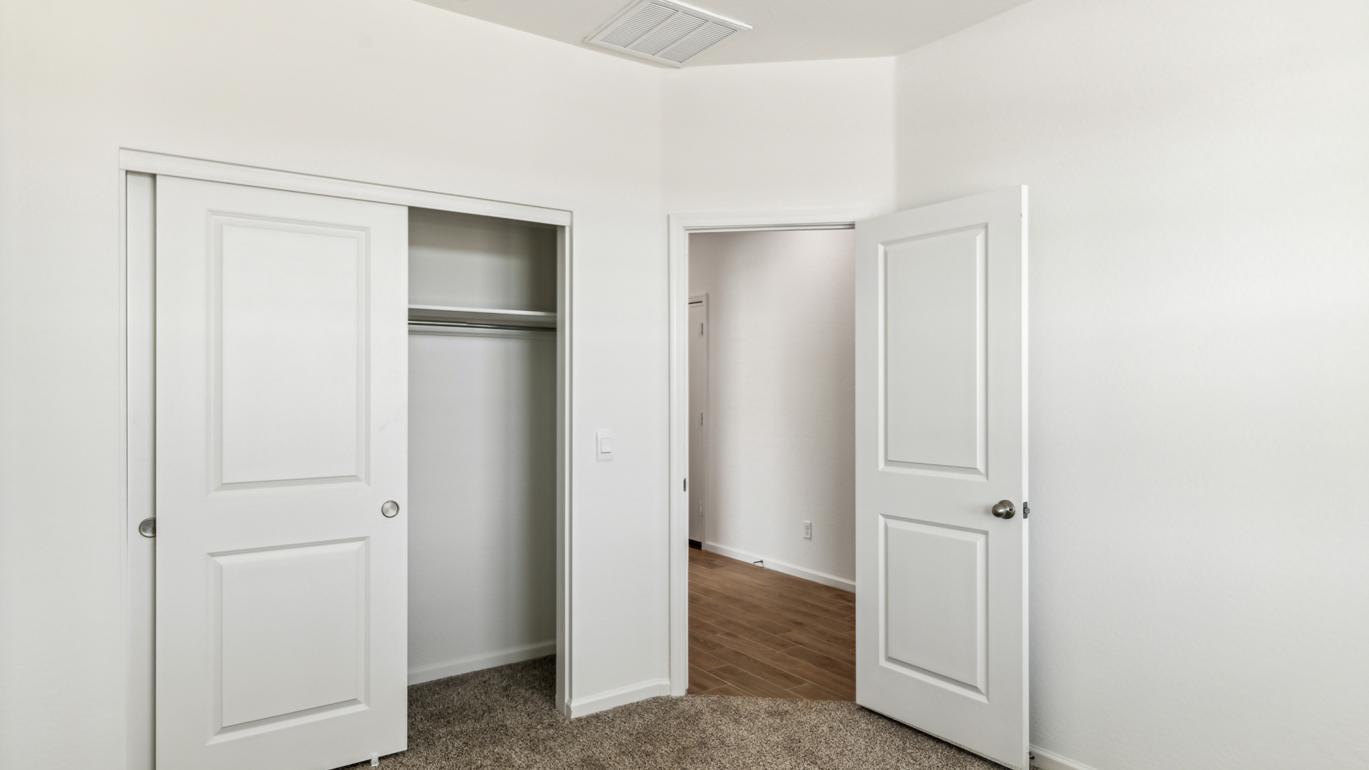 Comfortable guest bedroom featuring neutral-toned walls and a large closet.