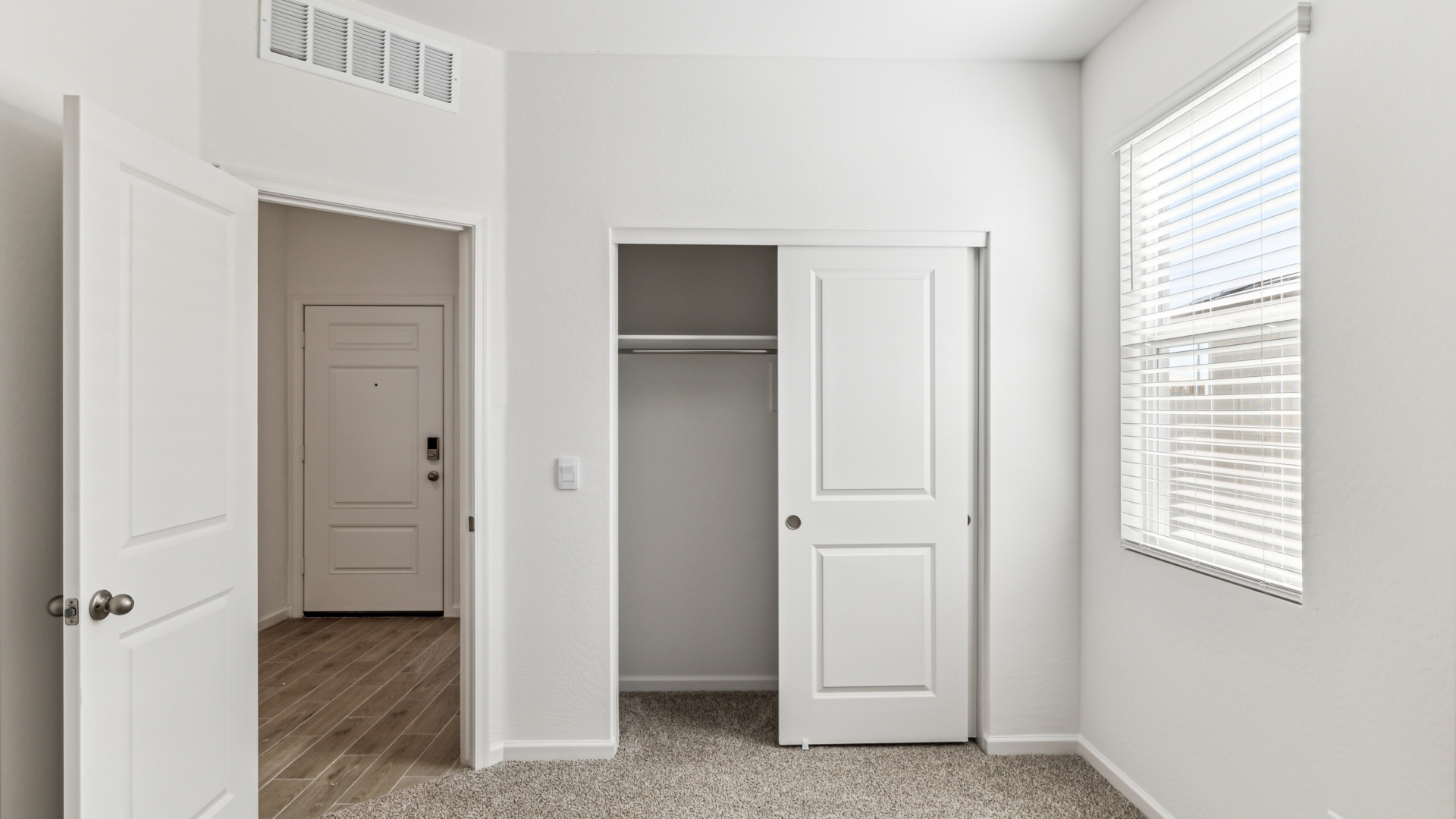 Comfortable guest bedroom featuring neutral-toned walls and a large closet.