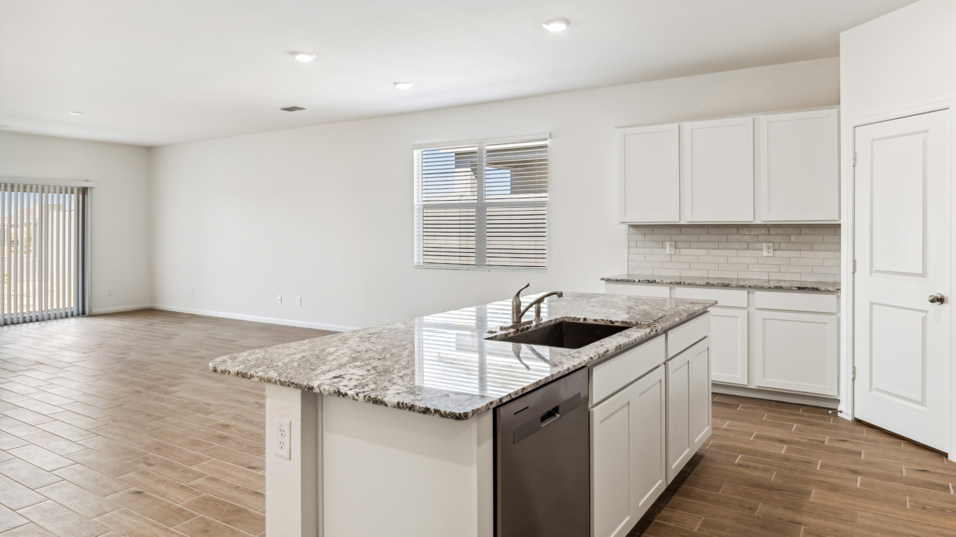 Bright and spacious kitchen with granite countertops, stainless steel appliances, and an island with bar seating.