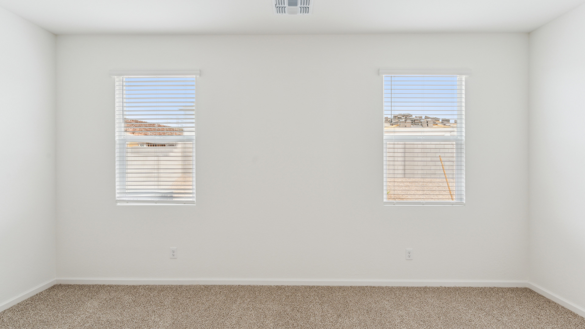 A spacious primary bedroom emphasizing open space and natural lighting.