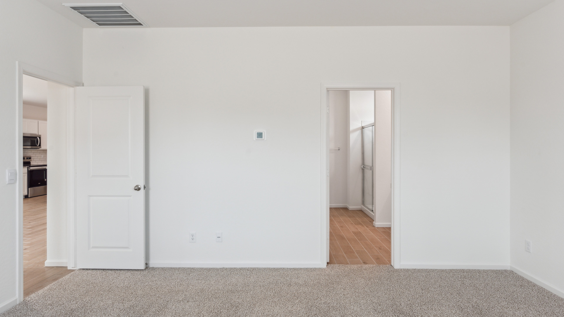 A spacious primary bedroom emphasizing open space and natural lighting.