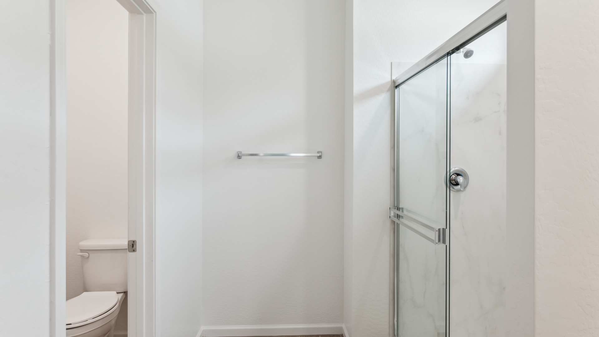 Modern primary bathroom with double vanities, countertops with a walk-in shower and a walk-in closet.