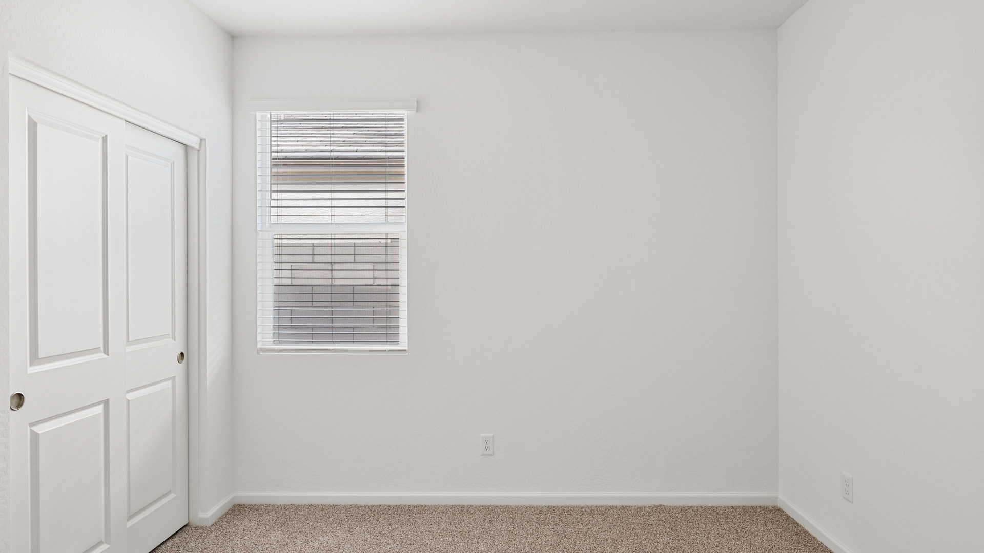 Comfortable guest bedroom featuring neutral-toned walls and a large closet.