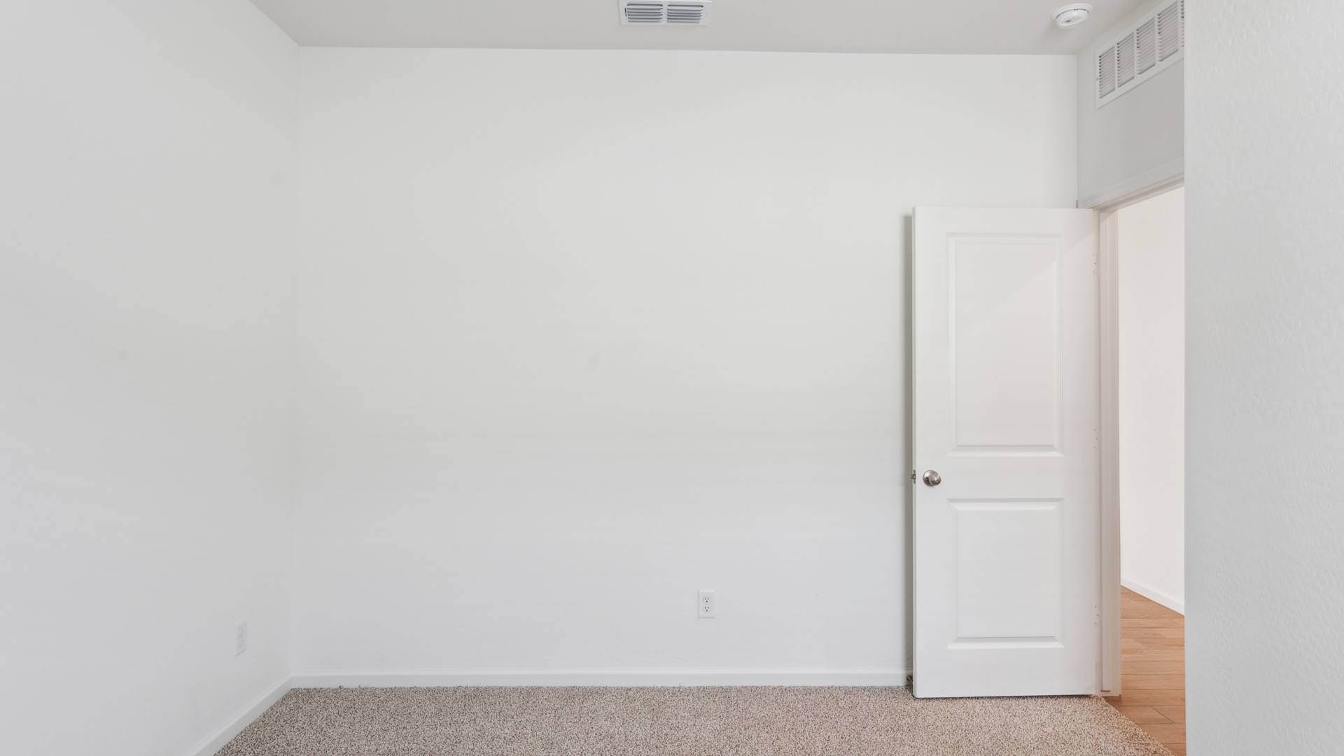 Comfortable guest bedroom featuring neutral-toned walls and a large closet.