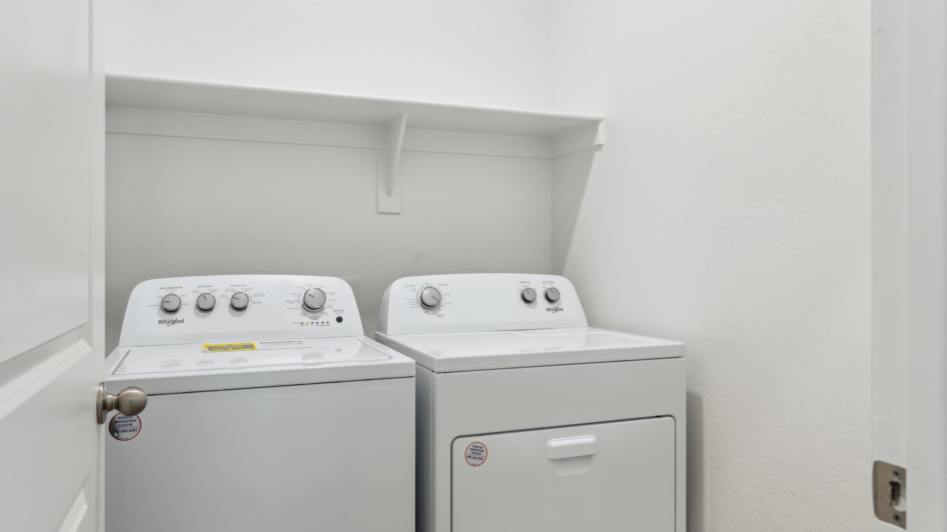 A laundry room featuring a washer and dryer, neatly arranged with ample space for laundry tasks and storage.