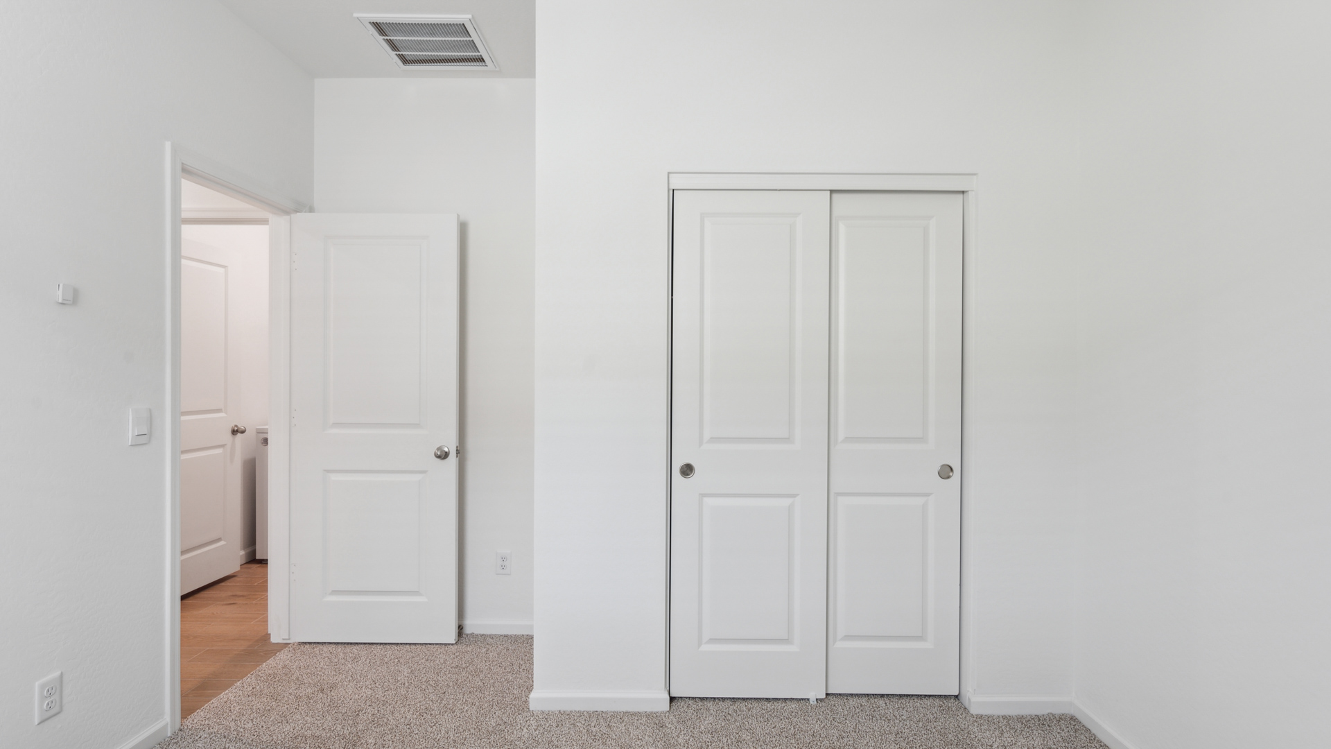 Comfortable guest bedroom featuring neutral-toned walls and a large closet.