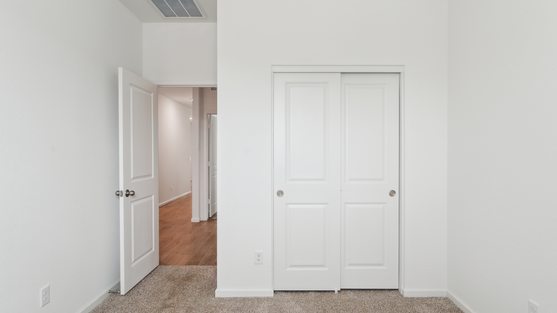 Comfortable guest bedroom featuring neutral-toned walls and a large closet.