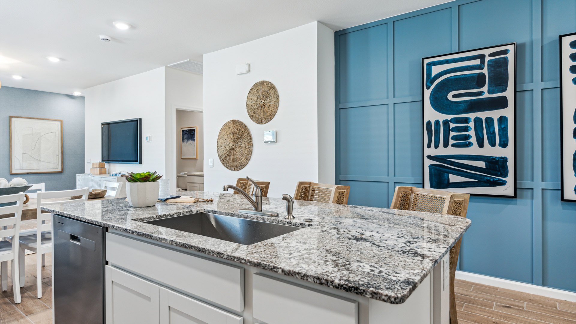 Bright and spacious kitchen with granite countertops, stainless steel appliances, and an island with bar seating.