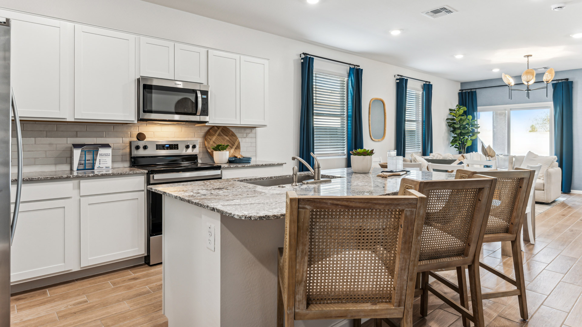 Bright and spacious kitchen with granite countertops, stainless steel appliances, and an island with bar seating.