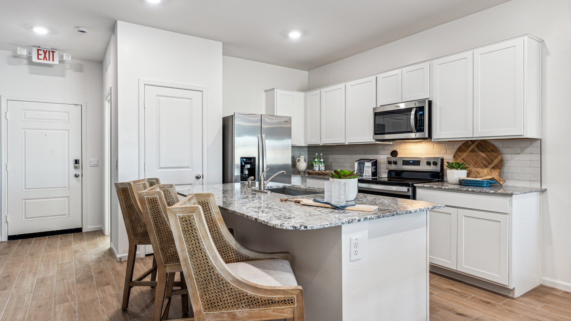 Bright and spacious kitchen with granite countertops, stainless steel appliances, and an island with bar seating.