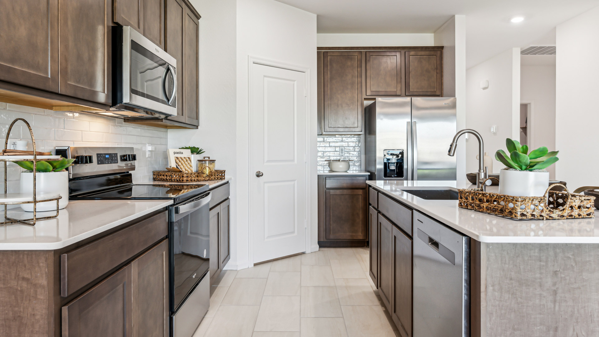 Bright and spacious kitchen with quartz countertops, stainless steel appliances, and an island with bar seating.
