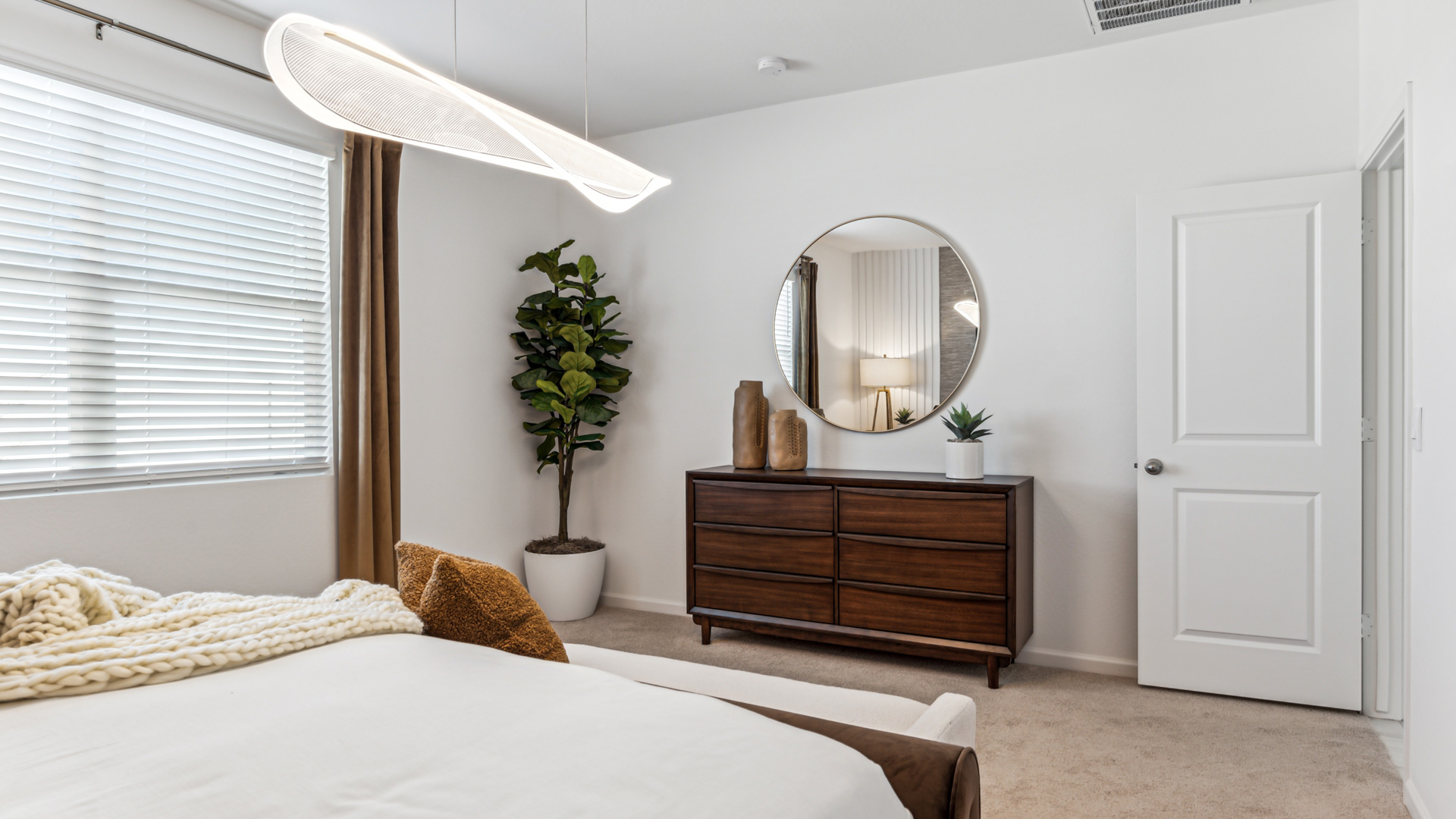 A spacious primary bedroom emphasizing open space and natural lighting.