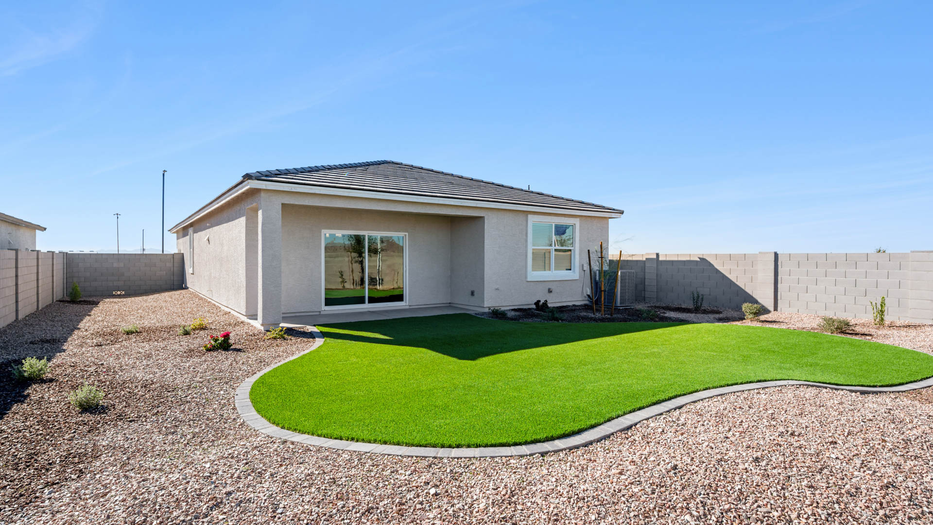 Outdoor covered patio with seating area overlooking a well-maintained lawn, perfect for relaxation.
