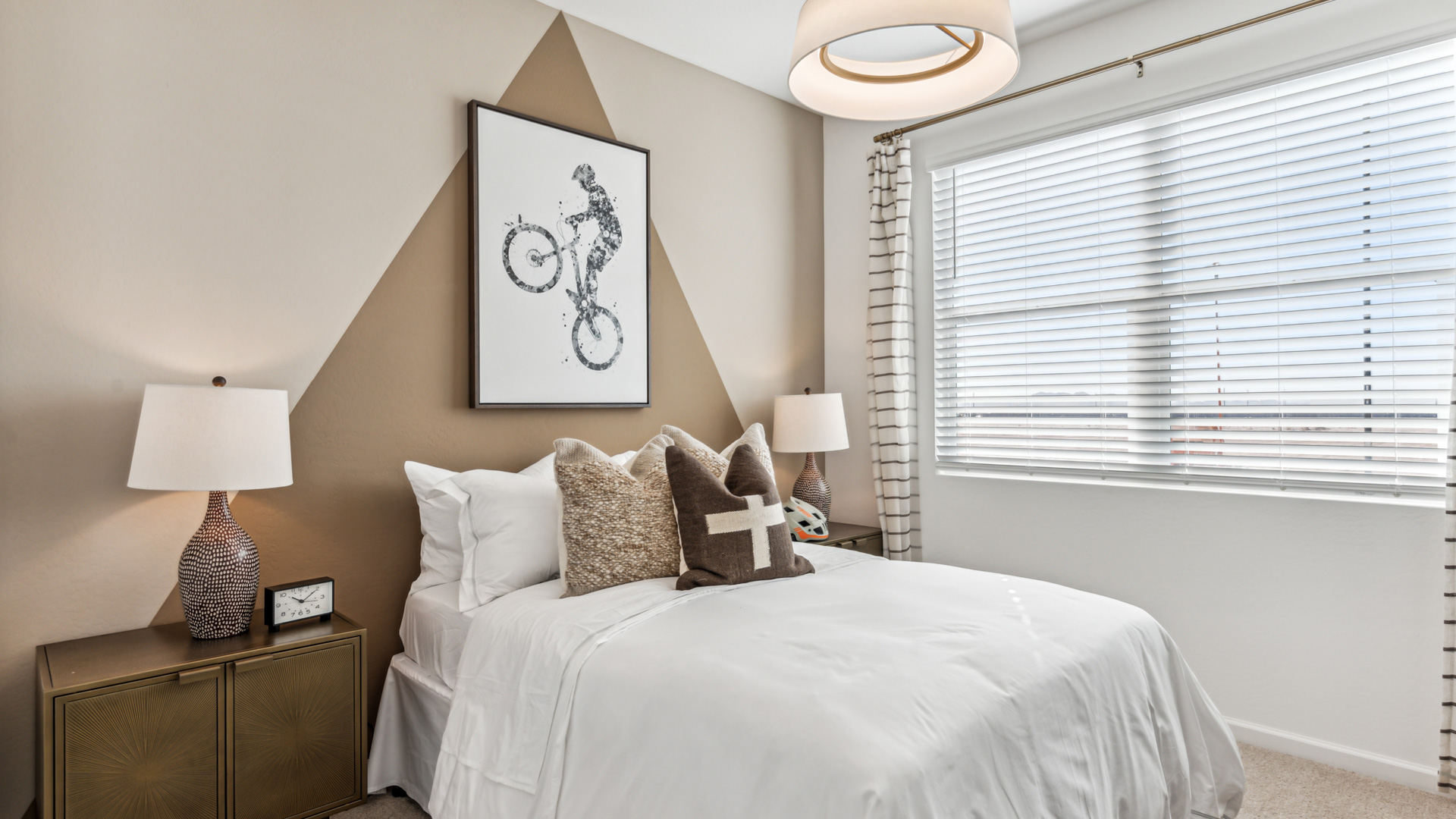 A vibrant kids' bedroom showcasing a neatly made bed, a stylish dresser, and a playful painting that adds charm.