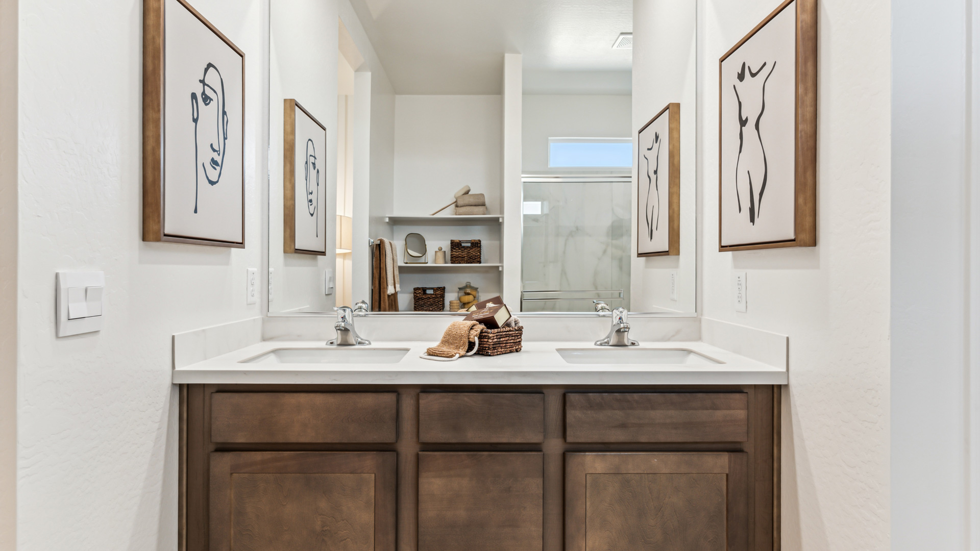 Primary bathroom with walk in shower and dual vanities.