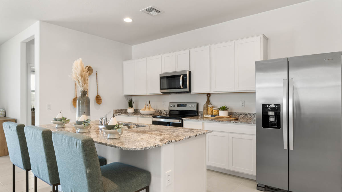 Spacious kitchen with island countertops and stainless steel appliances.