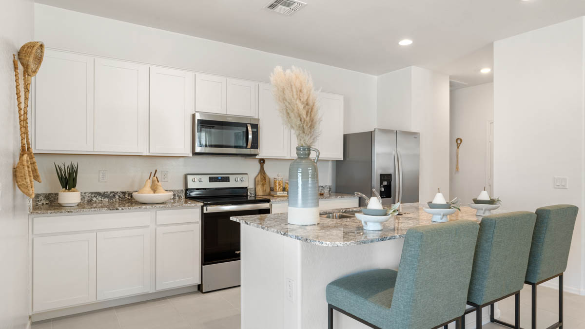 Spacious kitchen with island countertops and stainless steel appliances.
