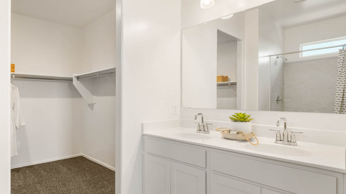 Primary bathroom with dual vanities and a walk-in shower.