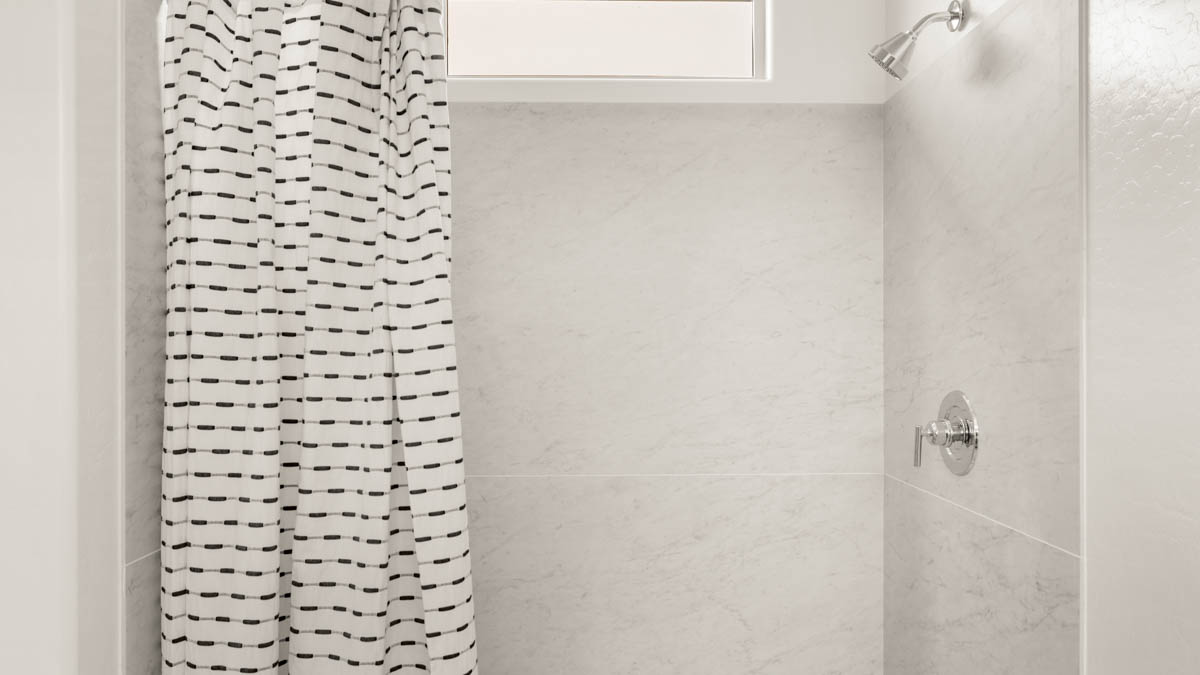 Primary bathroom with dual vanities and a walk-in shower.