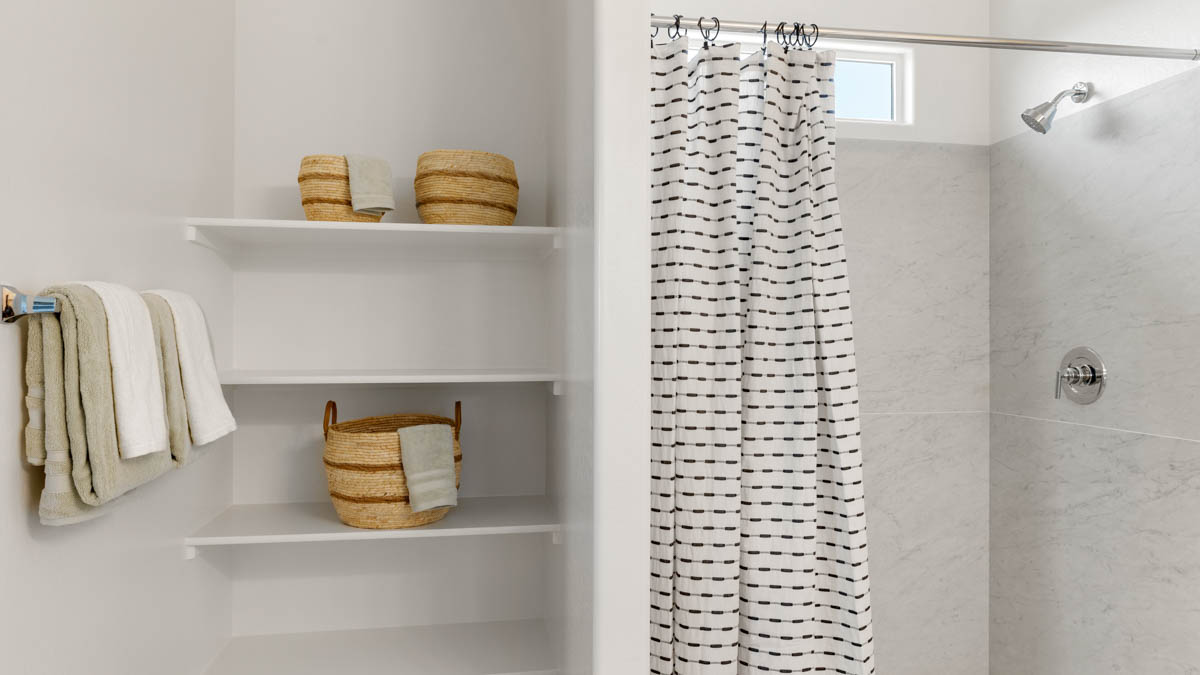 Primary bathroom with dual vanities and a walk-in shower.