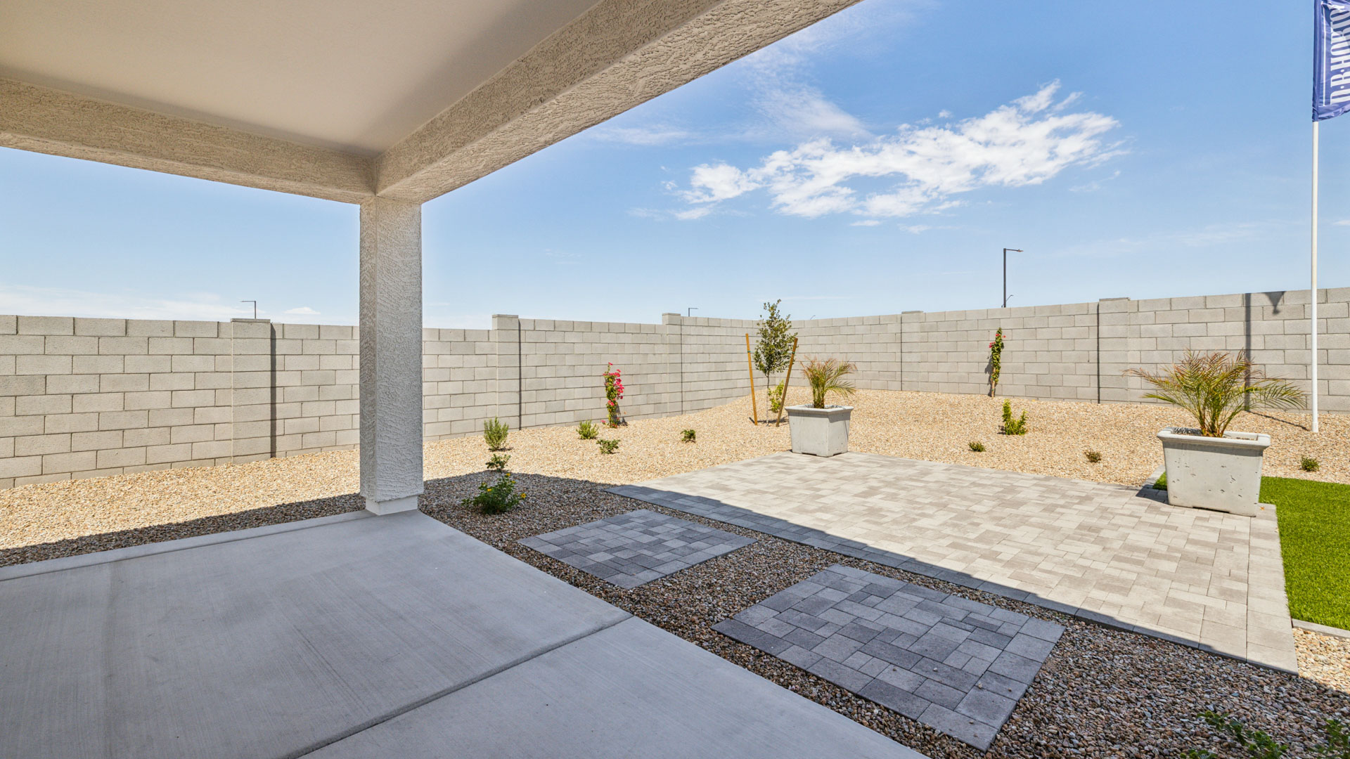Outdoor covered patio with seating area overlooking a well-maintained lawn, perfect for relaxation.