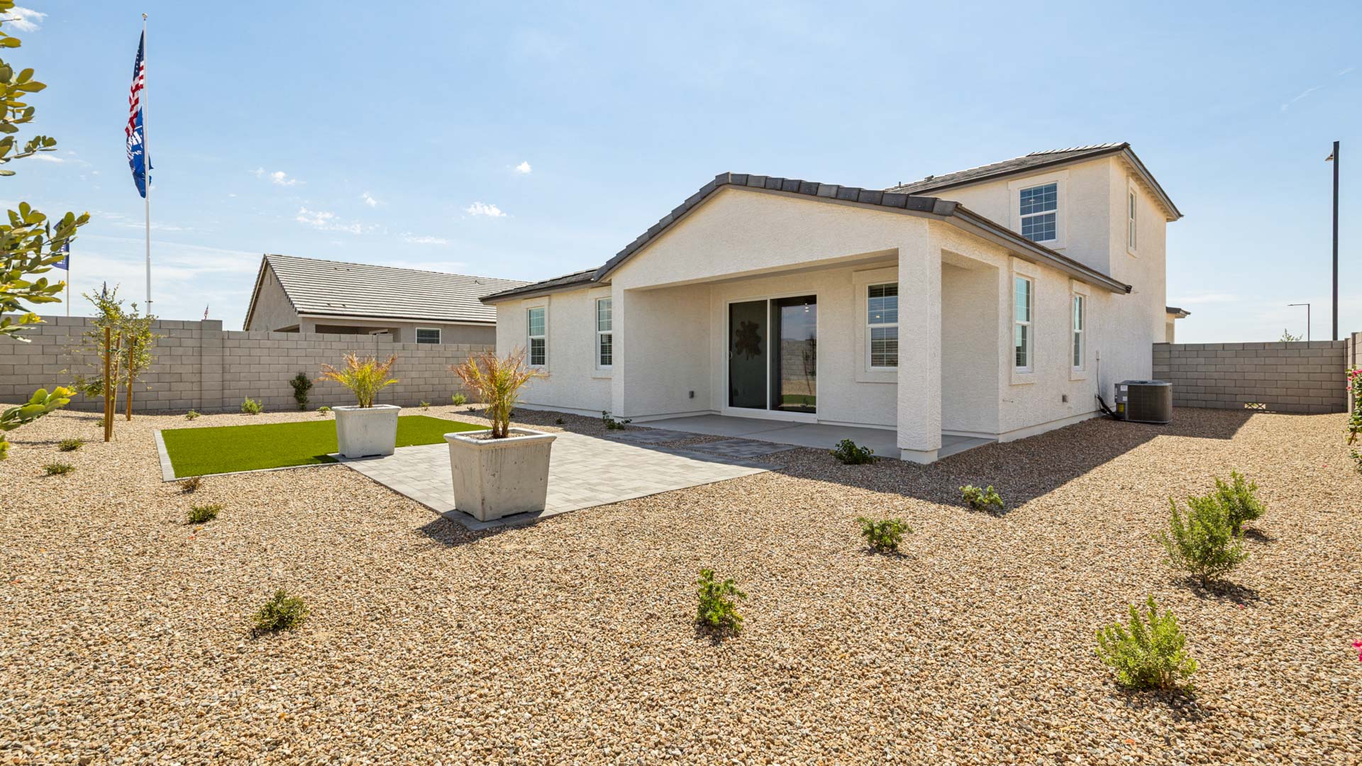 Outdoor covered patio with seating area overlooking a well-maintained lawn, perfect for relaxation.