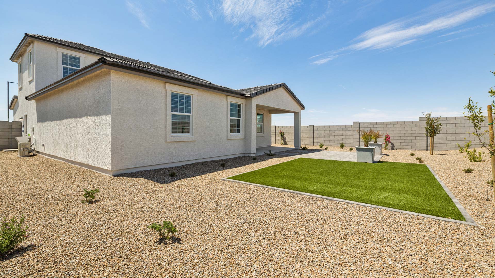 Outdoor covered patio with seating area overlooking a well-maintained lawn, perfect for relaxation.