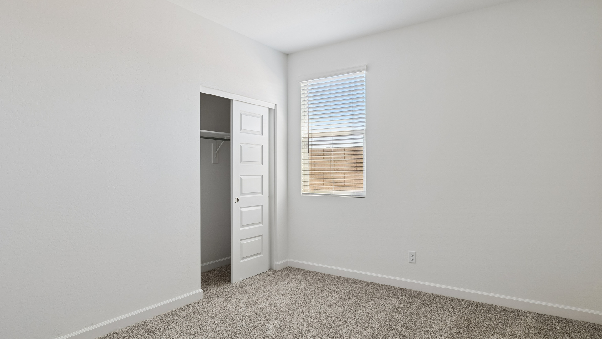 Comfortable guest bedroom featuring neutral-toned walls and a large closet.