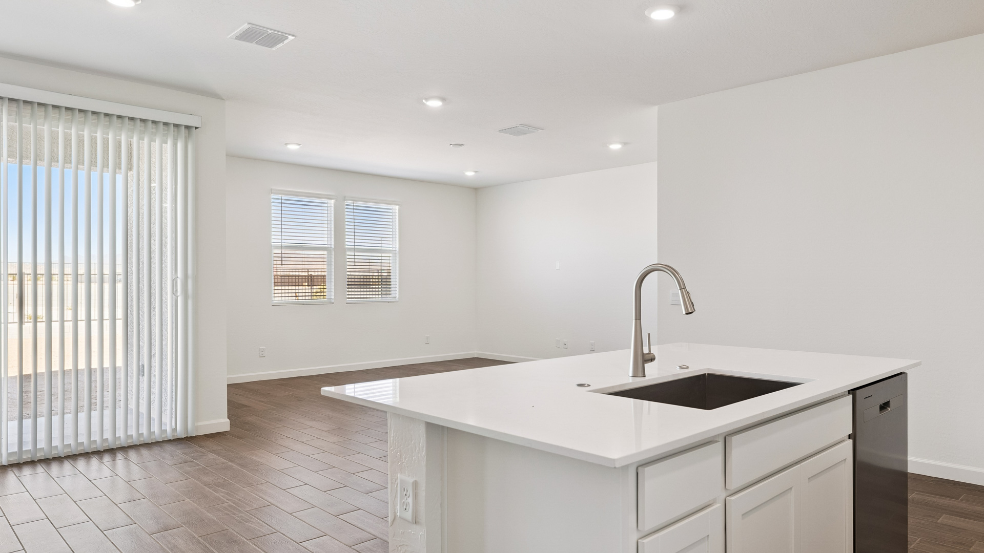 Bright and spacious kitchen with quartz countertops, stainless steel appliances, and an island with bar seating.