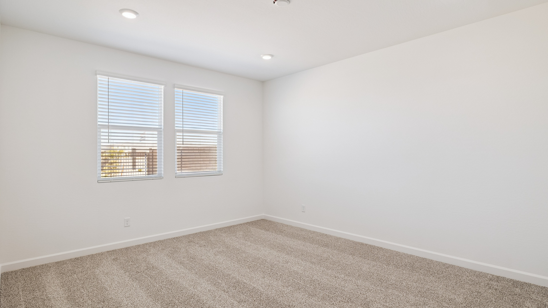 A spacious primary bedroom emphasizing open space and natural lighting.